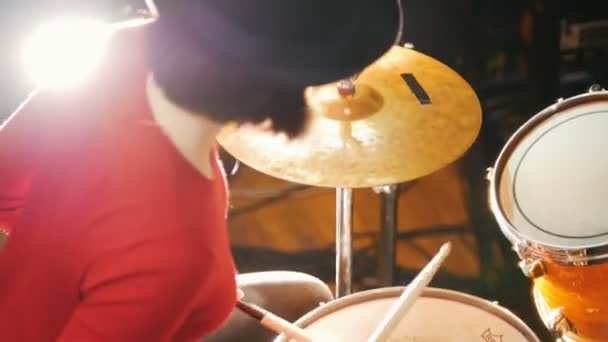 Repetition. Girl in black hat plays the drums. Bright lighting - 映像、動画