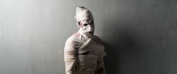 Terrorific mummy on textured wall background.  Halloween holidays - Φωτογραφία, εικόνα