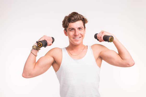 Sport, fitness and people concept - handsome athletic man with dumbbells on white background - Photo, Image