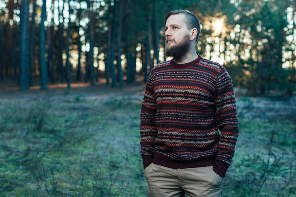 Portrait brutal bearded hipster man in the forest - Fotó, kép