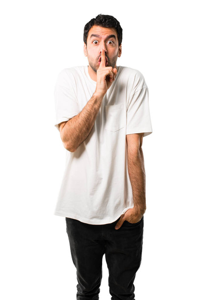 Mladý muž s bílou košilí, ukazující znamení zavírání úst a mlčení gesto uvedení prstem v ústech na izolované bílém pozadí - Fotografie, Obrázek