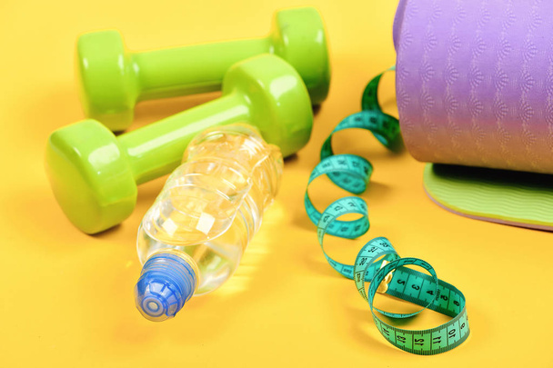 Shaping and fitness equipment. Dumbbells made of green plastic - Foto, Bild