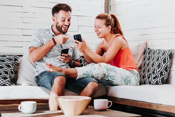 Couple relaxing in the living room using smartphones - Photo, Image