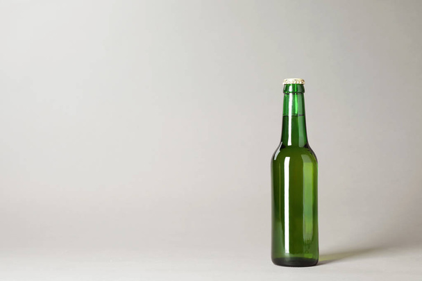 Bottle of beer on grey background. Space for text - Фото, зображення