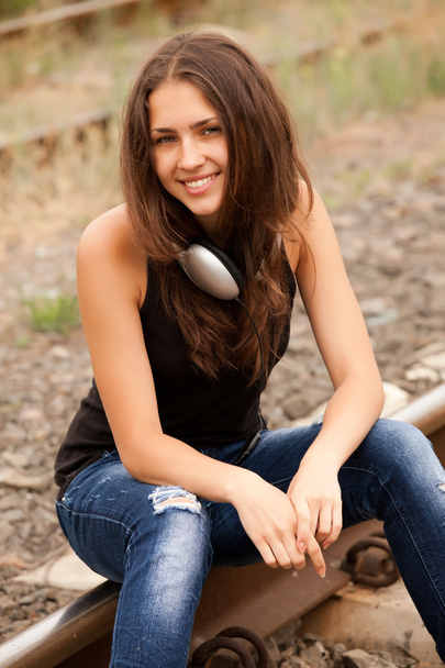 Chica adolescente con auriculares en los ferrocarriles
. - Foto, Imagen