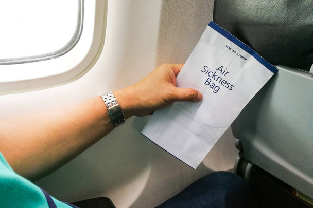 Matkustaja, jolla on lentosairaus oksennuspussi lentokoneessa hätätapauksia varten
 - Valokuva, kuva