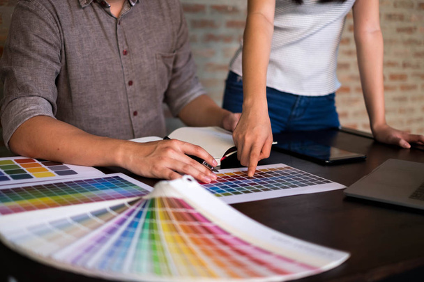 Γραφίστες επιλέξτε χρώματα από το χρώμα ζώνες δείγματα για σχεδιασμό. Η ΕΝΝΟΙΑ ΤΗΣ ΕΡΓΑΣΙΑΣ σχεδιαστής γραφικών δημιουργικότητα .  - Φωτογραφία, εικόνα