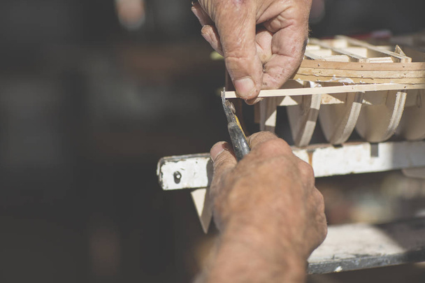 Παλιά ο άνθρωπος που εργάζεται για τη δημιουργία ένα ξύλινο μοντέλο μιας βάρκας - Φωτογραφία, εικόνα
