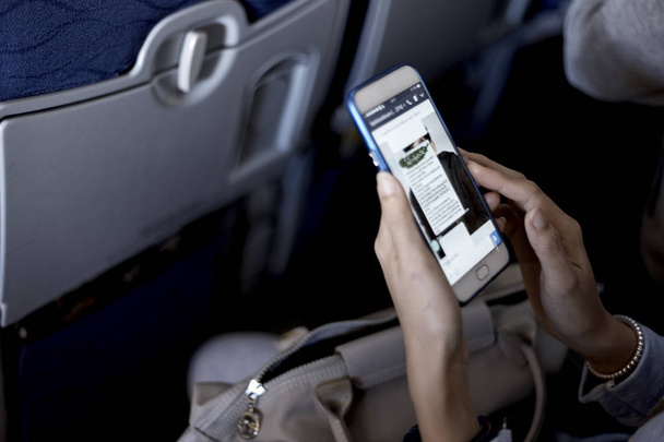 Genç kadın Asya Uçak, dünya seyahat kavramı, gece lambası smartphone kullanarak - Fotoğraf, Görsel