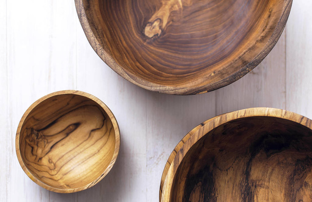 Utensili in legno per la cucina, ciotole, piatti su fondo chiaro. Il concetto di piatti naturali, uno stile di vita sano. Texture di legno. Eco-ware in legno
 - Foto, immagini