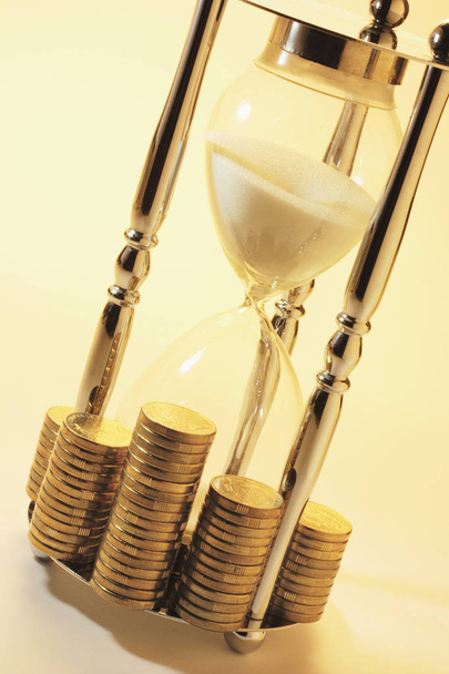 Hourglass and Coins with Warm Cast - 写真・画像