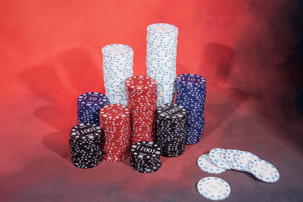 Abstraktní fotka z kasina. Poker hra na červeném pozadí. Téma hazardních her. - Fotografie, Obrázek