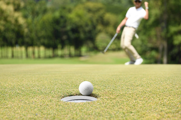 Homme golfeur acclamant après une balle de golf sur un vert de golf
 - Photo, image