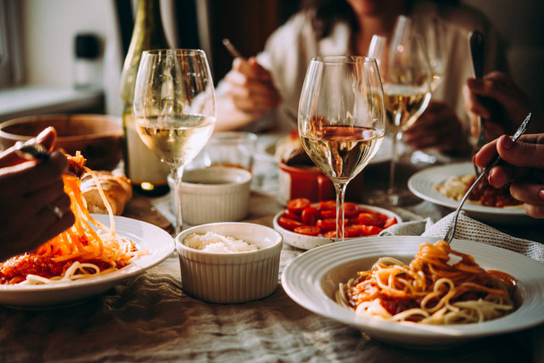 Friends having a pasta dinner at home of at a restaurant. - Foto, imagen
