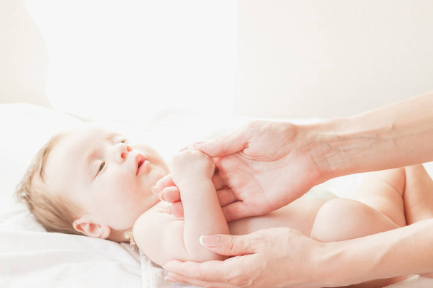 Baby and hands of mother, indoors, soft focus background - Photo, image