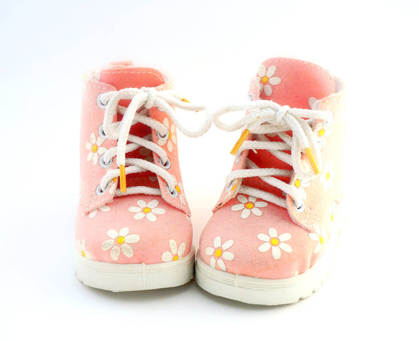 Baby pink shoes stand on a white background. Theme of newborns. - Фото, изображение