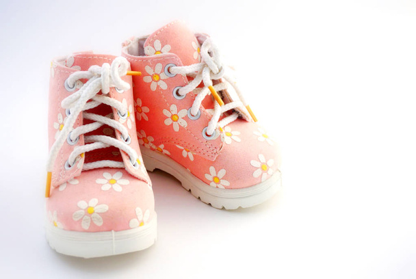 Baby pink shoes stand on a white background. Theme of newborns. - Φωτογραφία, εικόνα