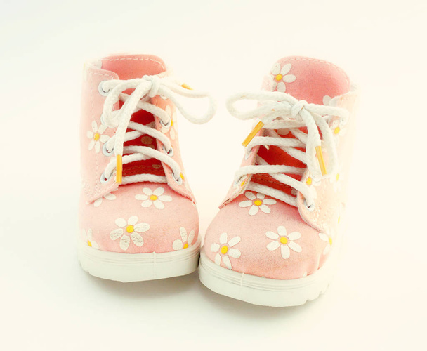 Baby pink shoes stand on a white background. Theme of newborns. - Φωτογραφία, εικόνα