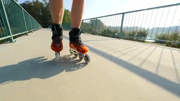 Close up van inline roller skater benen. Schaatsen in harde shell hi-tech schaatsen op lake brug weg.  - Video