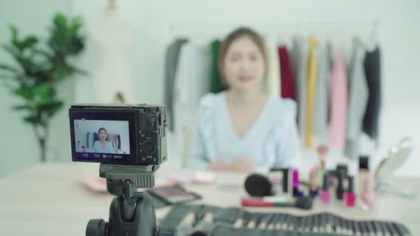Beauty-Blogger präsentieren Schönheitskosmetik, die vor der Kamera sitzt, um Videos aufzunehmen. schöne asiatische Frau verwenden Kosmetika, während Überprüfung Make-up-Tutorial Live-Video übertragen, um soziale Netzwerke über das Internet. - Filmmaterial, Video