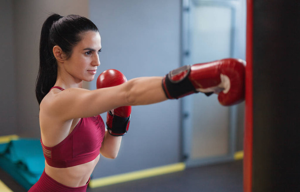 Sportieve vrouw boksen in sportschool - Foto, afbeelding