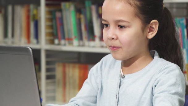 Κοντινό πλάνο του ένα όμορφο μικρό κορίτσι της Ασίας πληκτρολογώντας στο φορητό υπολογιστή - Φωτογραφία, εικόνα