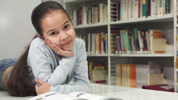 Jolie petite fille asiatique heureuse souriante agréable à lire un livre
 - Photo, image