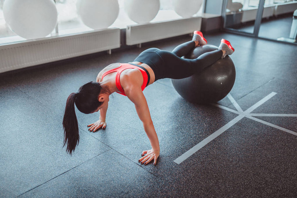 Anonymous woman doing plank on ball - Photo, Image
