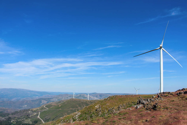 Vista deslumbrante da paisagem montanhosa rochosa com turbinas eólicas à distância. Belo céu azul claro. Aveiro, Portugal
 - Foto, Imagem