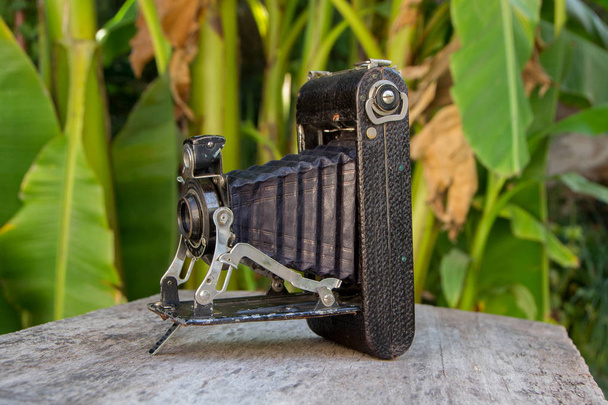 Old photo camera isolated on wooden background. Close up - Photo, Image