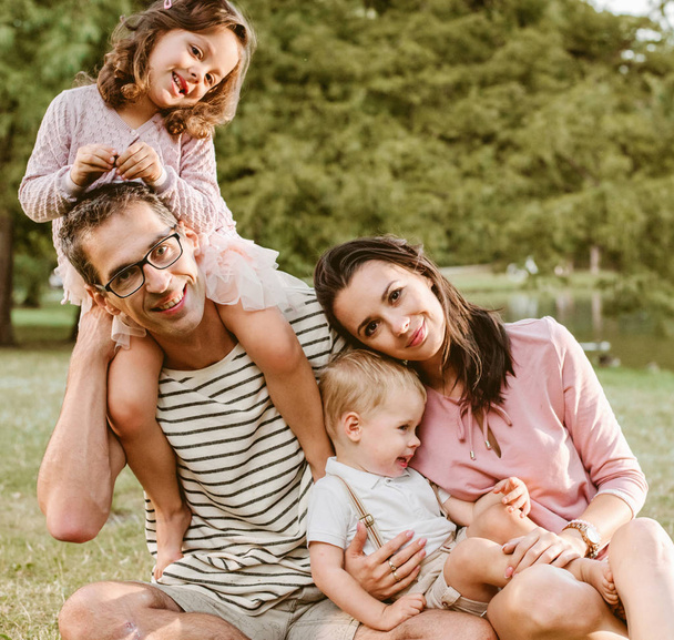 Portrait of cheerful family resting in the summer park - Photo, image