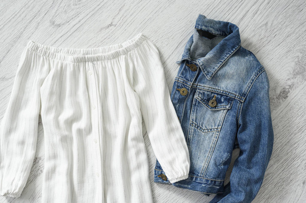 Bílá halenka a džínové sako na dřevěné pozadí. Módní pojem - Fotografie, Obrázek