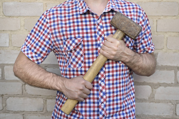 Man with a hammer, on the brick wall background. Working concept - Fotoğraf, Görsel