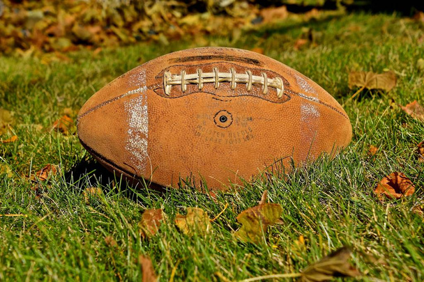 Μια παλιά δερμάτινη ποδόσφαιρο φέρει πίσω το φθινόπωρο αναμνήσεις μιας περασμένης εποχής, η σχάρα. - Φωτογραφία, εικόνα
