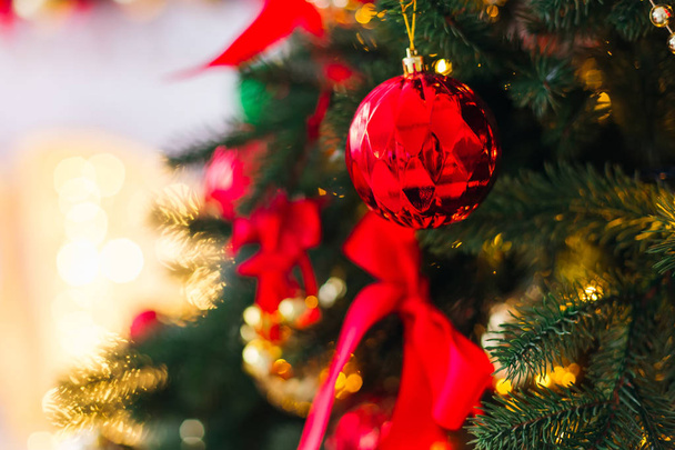 Ένα κοντινό πλάνο του μια όμορφη σκαλιστά γυάλινη σφαίρα, πάνω σε ένα κλαδί ενός χριστουγεννιάτικου δέντρου - Φωτογραφία, εικόνα