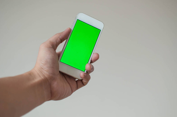Joven sosteniendo un teléfono inteligente con pantalla verde
 - Foto, Imagen