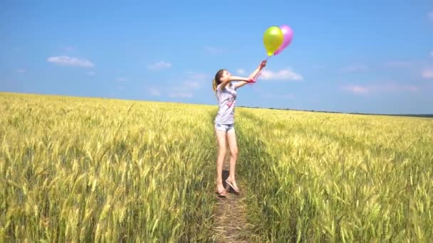 Teen κορίτσι με μπαλόνια άλματα στον τομέα - Πλάνα, βίντεο