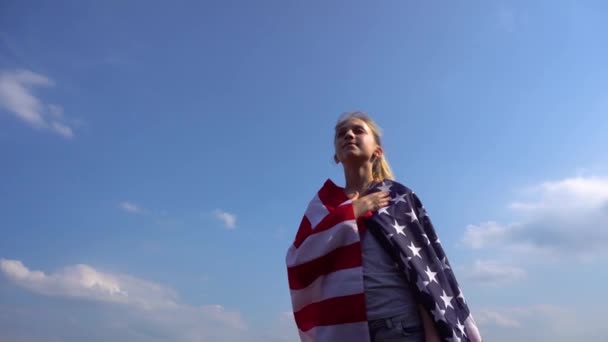 Молодая патриотичная женщина с флагом США в природе
 - Кадры, видео