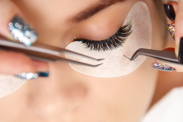 Eyelash Extension Procedure. Woman Eye with Long Eyelashes. Close up, selective focus. - Photo, Image