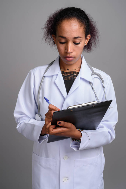 Молодая красивая африканская женщина врач на сером фоне - Фото, изображение