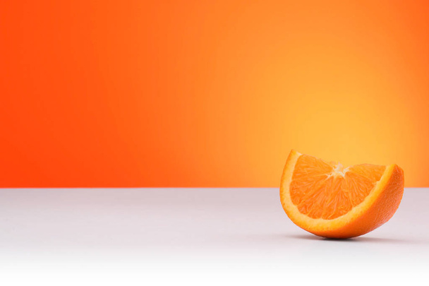 A piece of orange isolated on an orange and white background with space for text - Zdjęcie, obraz