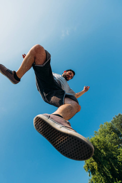 Young man doing parkour jumping at skatepark - Fotó, kép