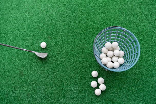 Golf club e palle su un tappeto di erba sintetica in un campo pratica
. - Foto, immagini