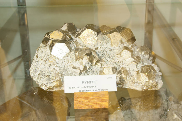 Mineral de pirita cúbica natural en exhibición pública
 - Foto, imagen