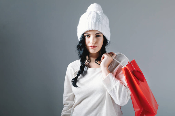 Happy young woman holding a shopping bag - 写真・画像