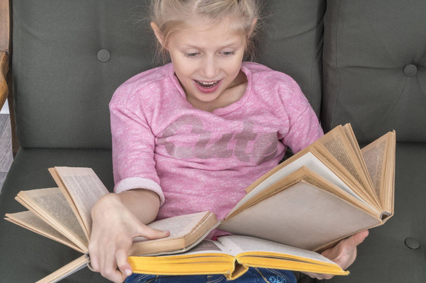 child reads many books at once - Фото, изображение