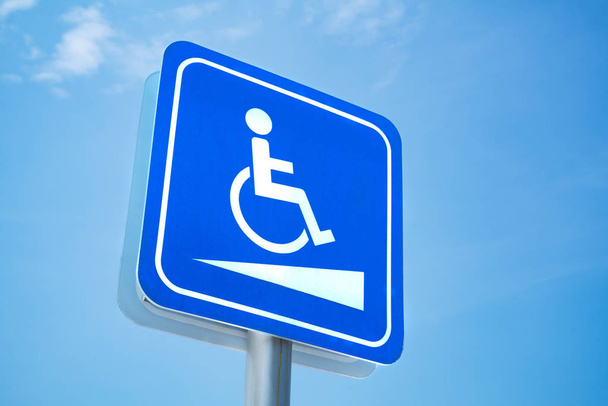 Señal para discapacitados. Símbolo blanco sobre fondo azul sobre fondo azul cielo
 - Foto, imagen
