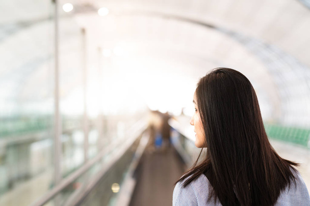 viajero con bolsa de viaje o equipaje caminando en la pasarela terminal del aeropuerto para viajar en avión. movimiento borroso - Foto, imagen
