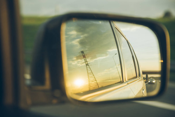 car on highway. sunset in car mirror reflection. road trip - Photo, Image