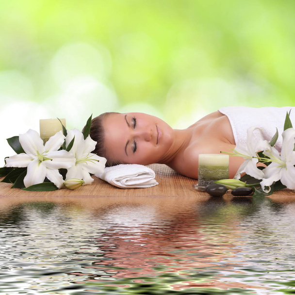 woman lying down relaxing on a massage bed at a spa - Photo, Image